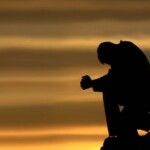 Một chàng trai gục đầu bên bức tường xám Một chàng trai gục đầu bên bức tường xám