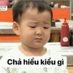 Một em bé buồn cúi đầu bên gối mềm Một em bé buồn cúi đầu bên gối mềm